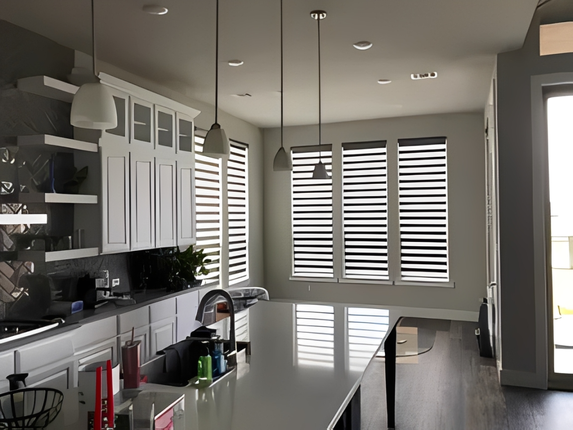 Sunlit kitchen featuring sleek countertops and blinds.