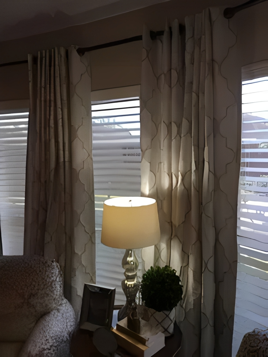 Elegant curtains beside a lit lamp