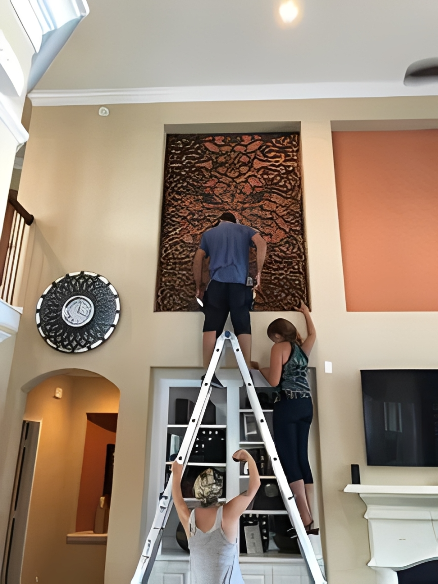 People on ladder decorating wall